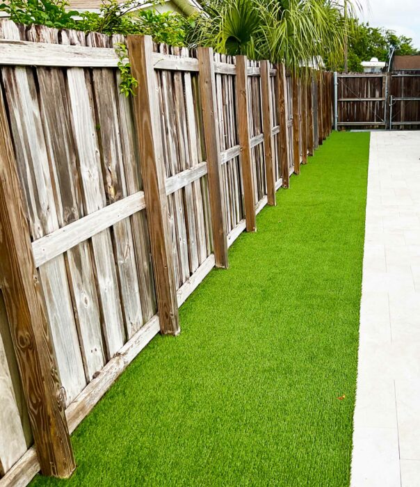 Synthetic turf along a fence and patio in Boca Raton, FL