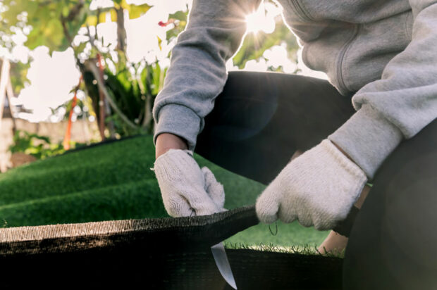 Artificial grass installation in Jupiter being cut to the correct dimensions