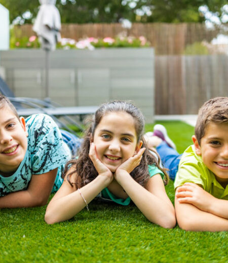 Three children Resting on Synthetic Grass in Boca Raton, FL